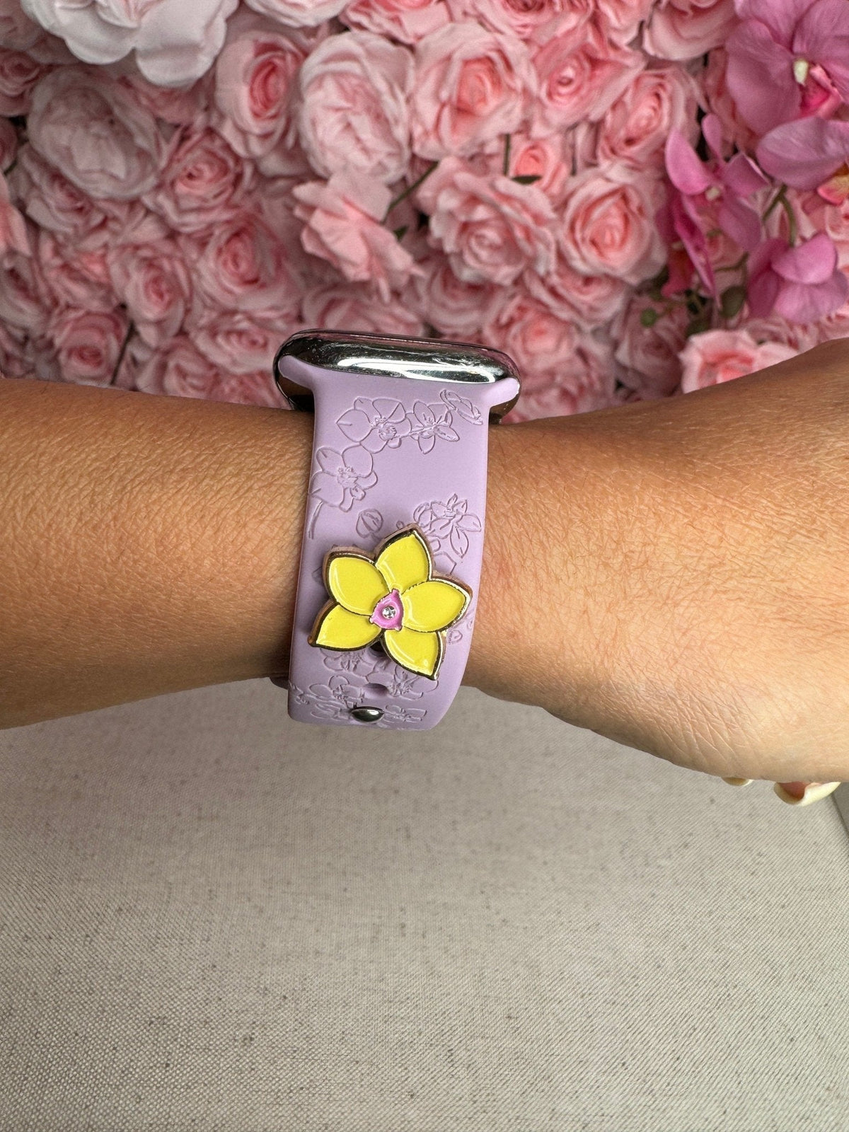 Lavender engraved watch band on the wrist with a yellow Phalaenopsis charm