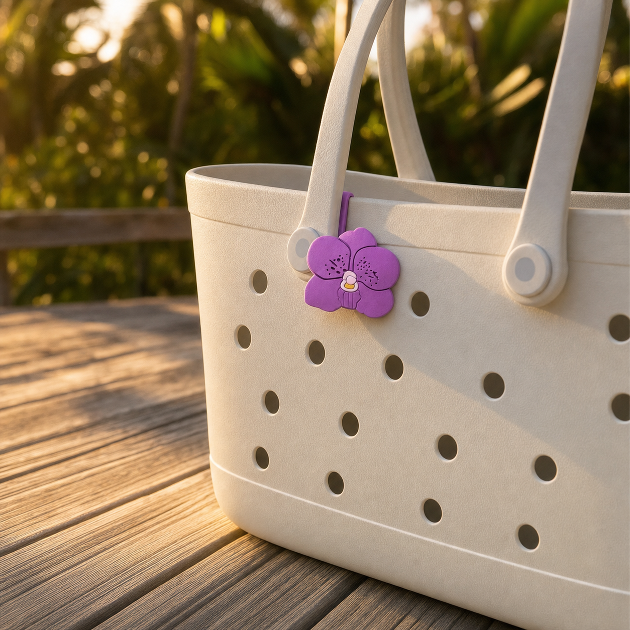 Purple Vanda orchid bag charm clipped to white beach tote on wooden boardwalk at golden hour - Orchidique