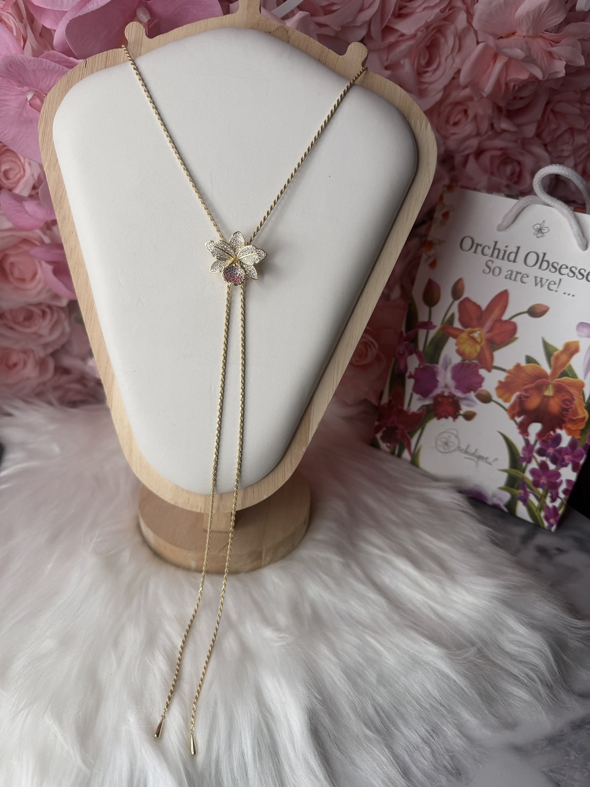 cattleya orchid necklace, 14K gold plated sterling silver, on display bust with pink roses – Orchidique