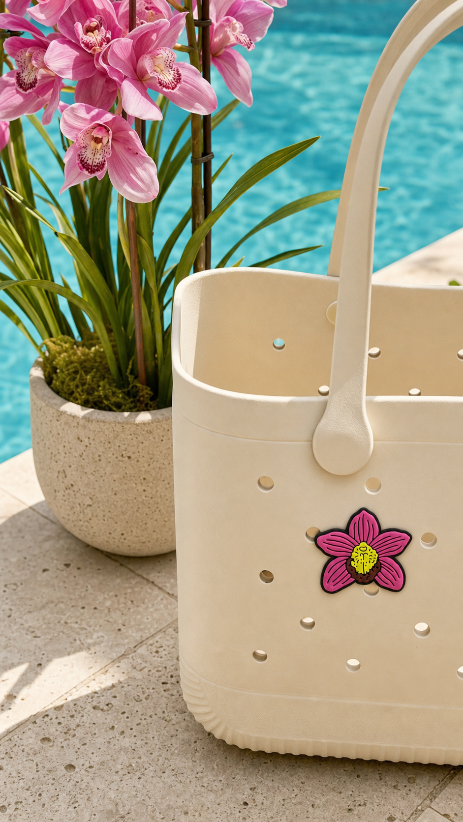 Pink Cymbidium orchid bag charm popped into cream tote drainage hole poolside with Cymbidium plant - Orchidique