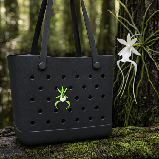 Ghost orchid PVC tote bag charm on black tote in the forest