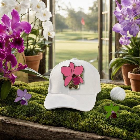 Cattleya Luddy Orchid golf hat charm on a white golf cap in a moss greenhouse overlooking the golf course