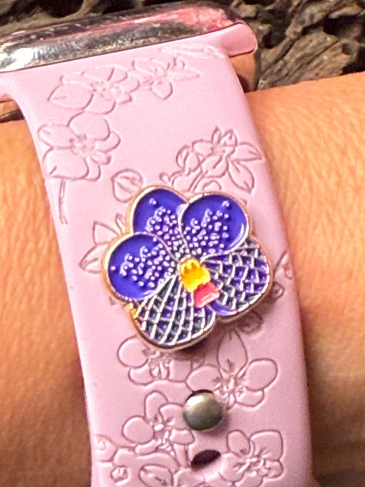 Pink engraved watch band on the wrist with a Vanda orchid charm