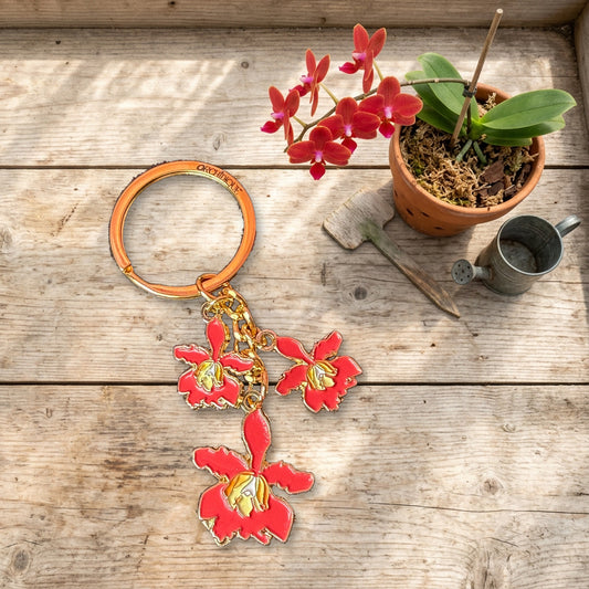 Red enamel orchid keychain on a greenhouse potting bench
