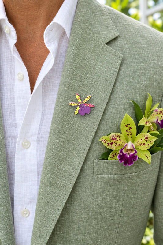 Lime Laelia Cattleya orchid enamel pin on a sage linen blazer lapel with spotted lime Cattleya blooms