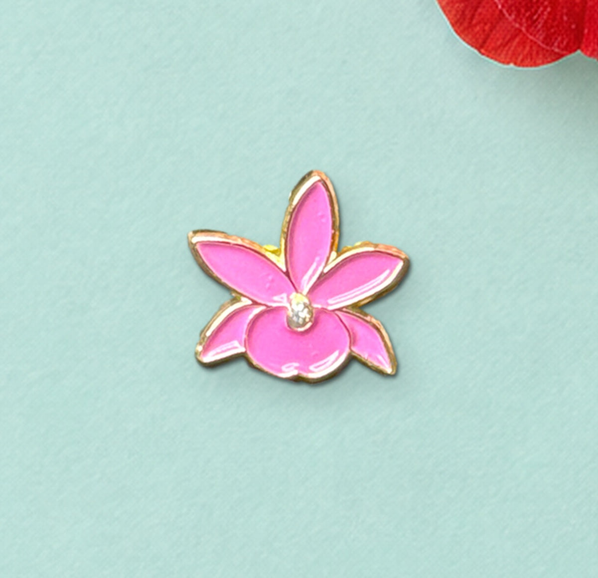 Close-up of the Fuchsia mini Broughtonia enamel pin with gold-tone outline and crystal center