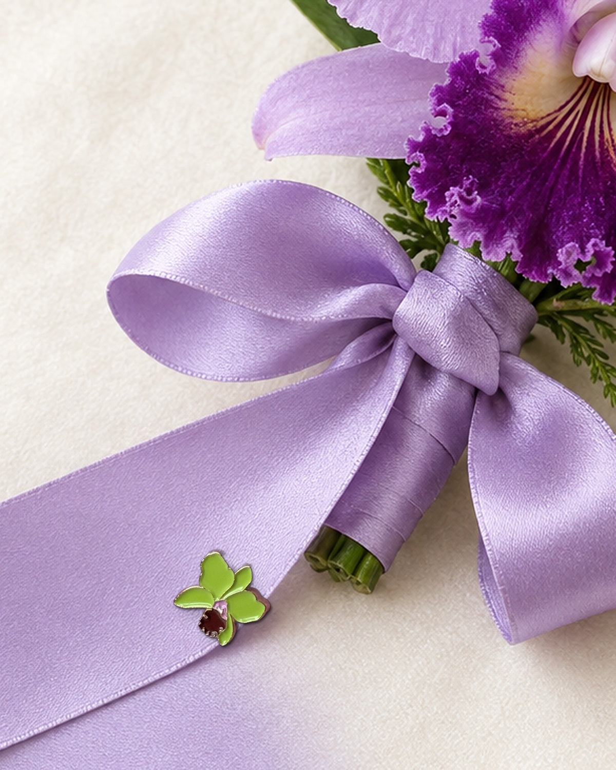 Green mini Cattleya enamel pin with burgundy lip on the lavender satin ribbon of a real Cattleya orchid corsage