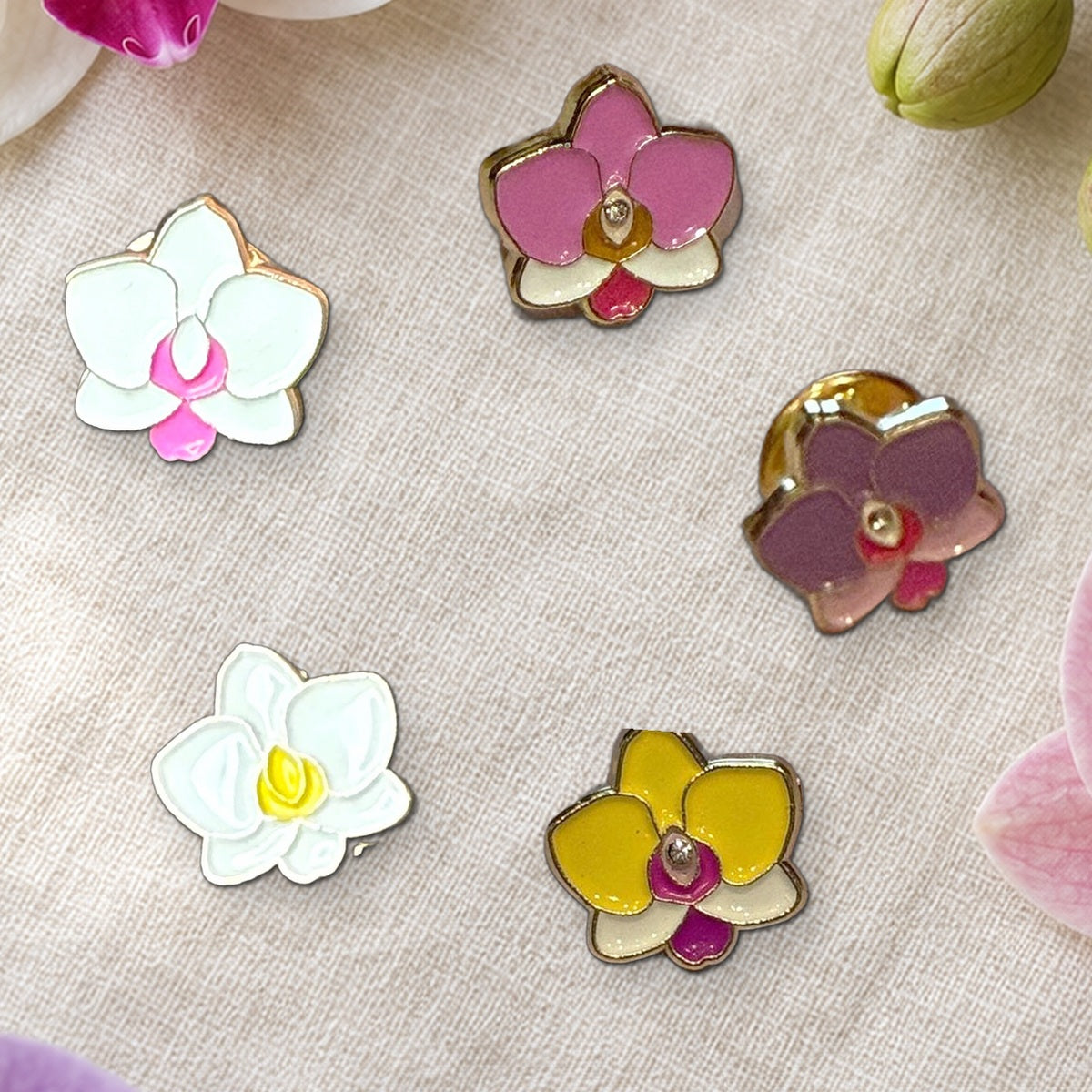 Close-up of the five 14mm mini Phalaenopsis enamel pins: white and pink, pink, purple, white and yellow, and yellow