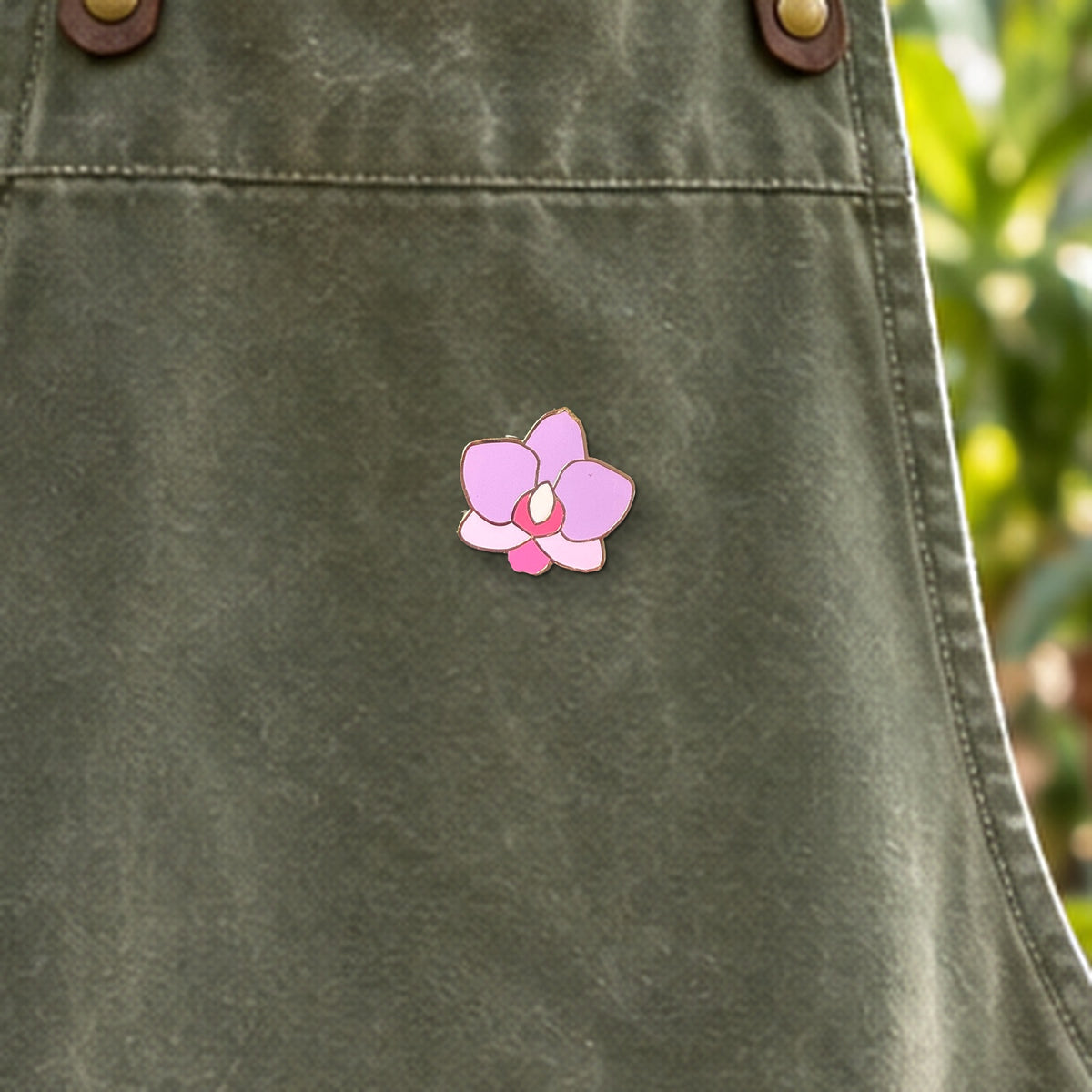 Pink Phal Cutie enamel pin close-up on waxed canvas apron