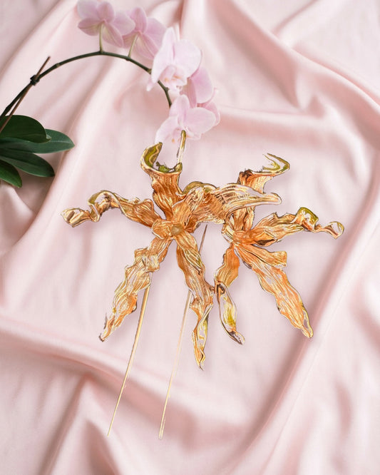 Schomburgkia Orchid Dangle Earrings in rose gold, pair styled on blush silk with a pink orchid